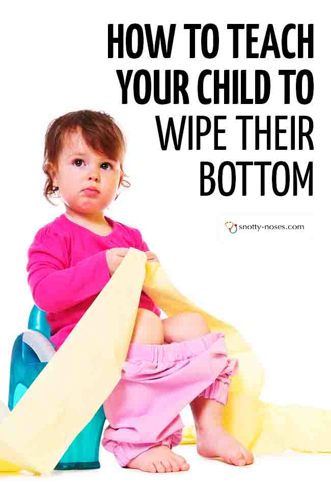 A little girl sitting on a potty, holding some rolls of toilet paper (learning to wipe her bottom). #parenting #toddler #wipebottom #toilettraining #pottytraining #toiletingkid